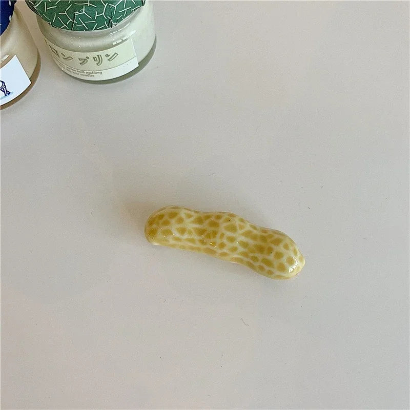Small kawaii chopstick holder shaped like a peanut on a light gray surface