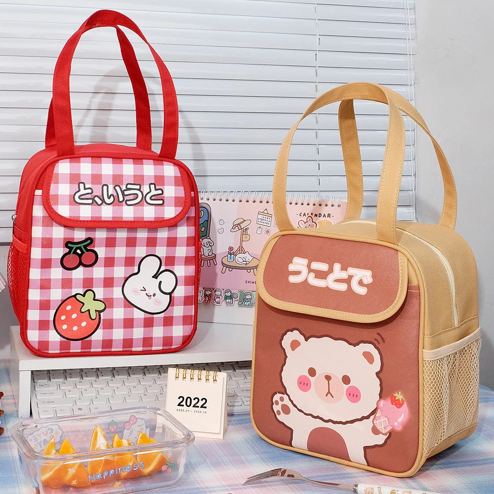 Two cute kawaii lunch bags on a desk with a calendar and snacks.