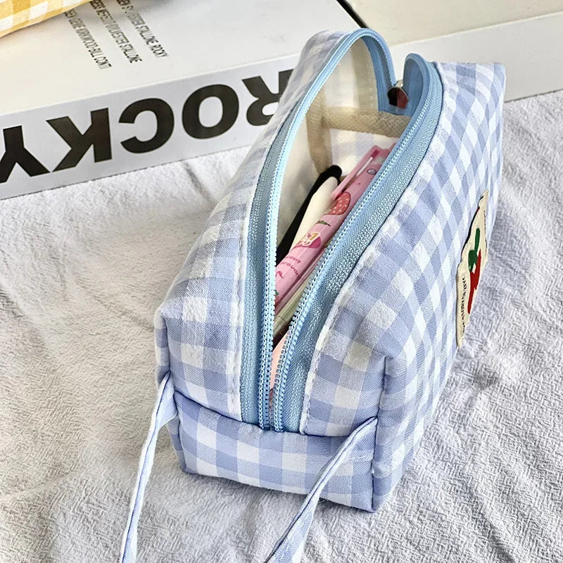 Blue checkered kawaii pouch with a zipper on a light gray surface