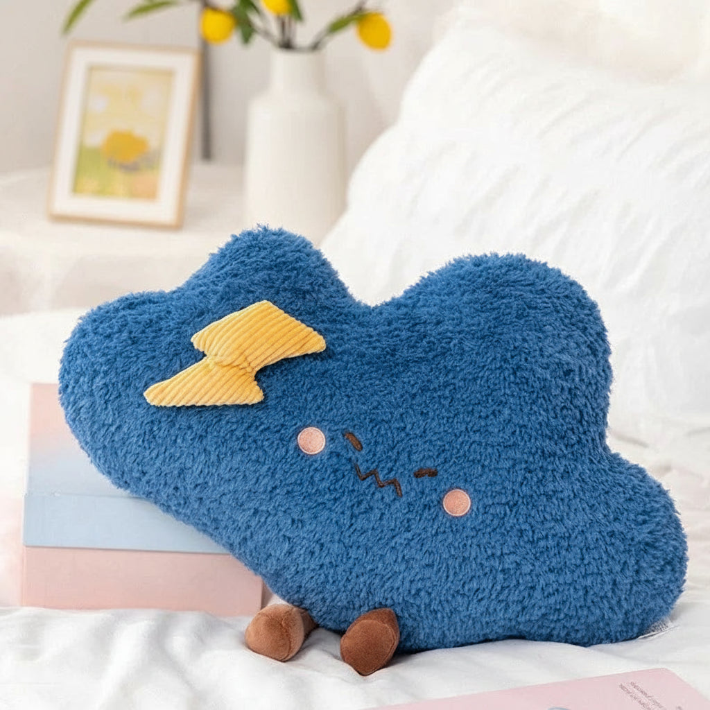 Blue cloud-shaped kawaii pillow with a yellow lightning bolt on a white surface