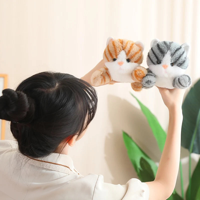 Person holding two kawaii plush cat toys against a neutral background
