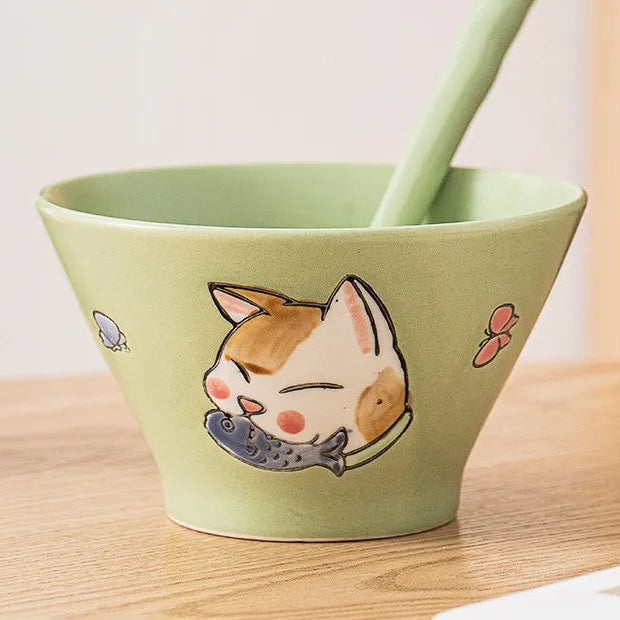 Green ceramic kawaii ramen bowl with a cat illustration on a wooden surface
