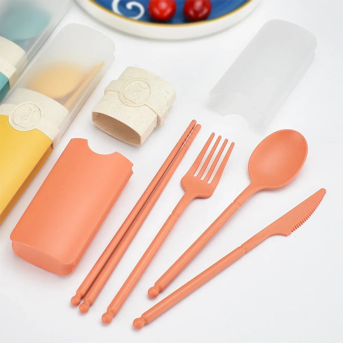 A set of orange kawaii utensils with case on a table