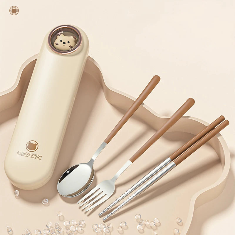 Set of kawaii utensils including a spoon, fork, and chopsticks with a carrying case on a beige background.