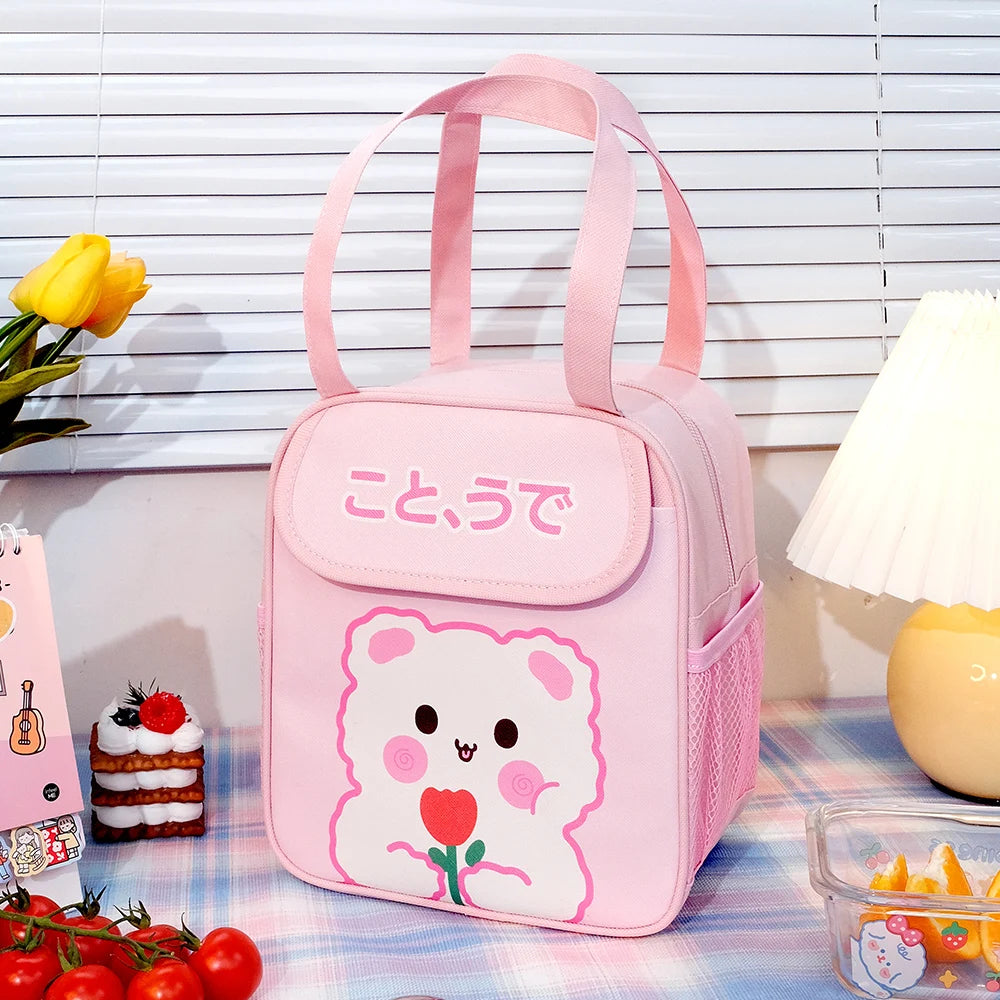 Pink kawaii lunch bag with cartoon design on a table with snacks and flowers