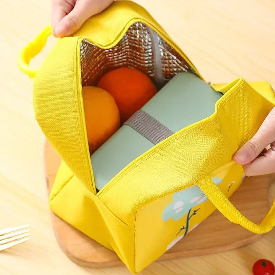 Yellow kawaii lunch bag with large opening design, holding food items on a light blue background.