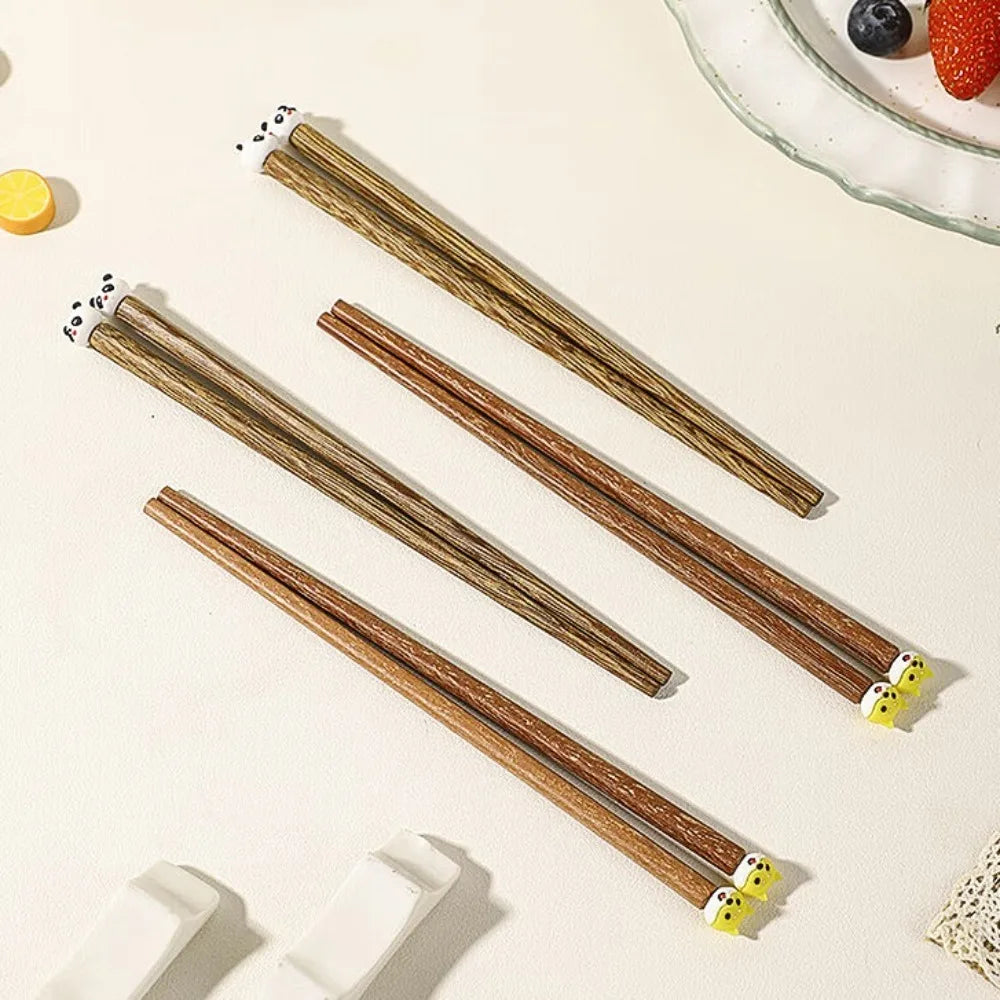Set of wooden kawaii chopsticks with decorative ends on a light background