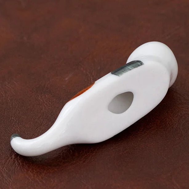 White ceramic kawaii chopstick holders on a brown leather background