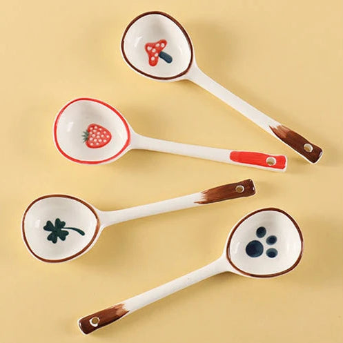 Set of four ceramic kawaii spoons with animal-themed bowls on a beige background