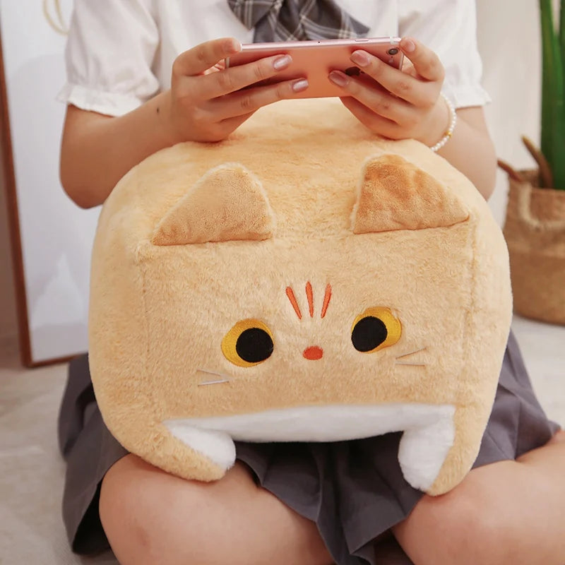 Person holding a kawaii plush cat pillow while using a phone.