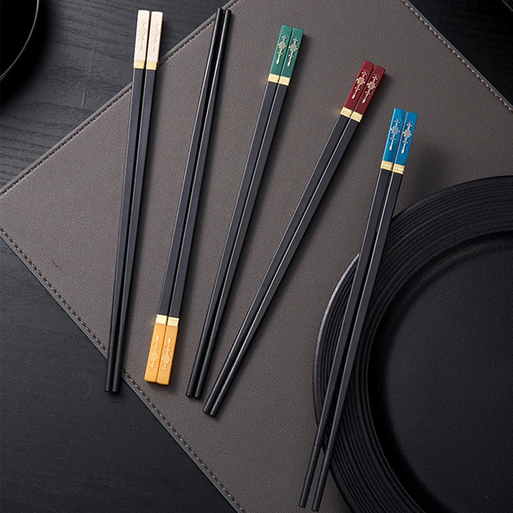 Set of black kawaii chopsticks with colorful tips on a dark surface