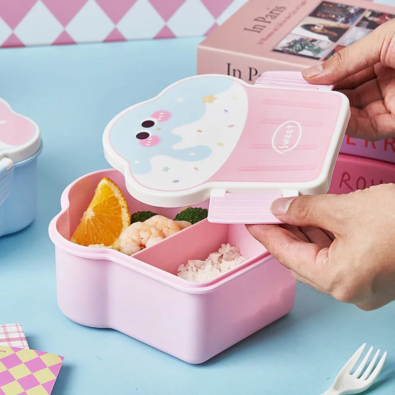 Pink kawaii bento box with food compartments on a blue surface