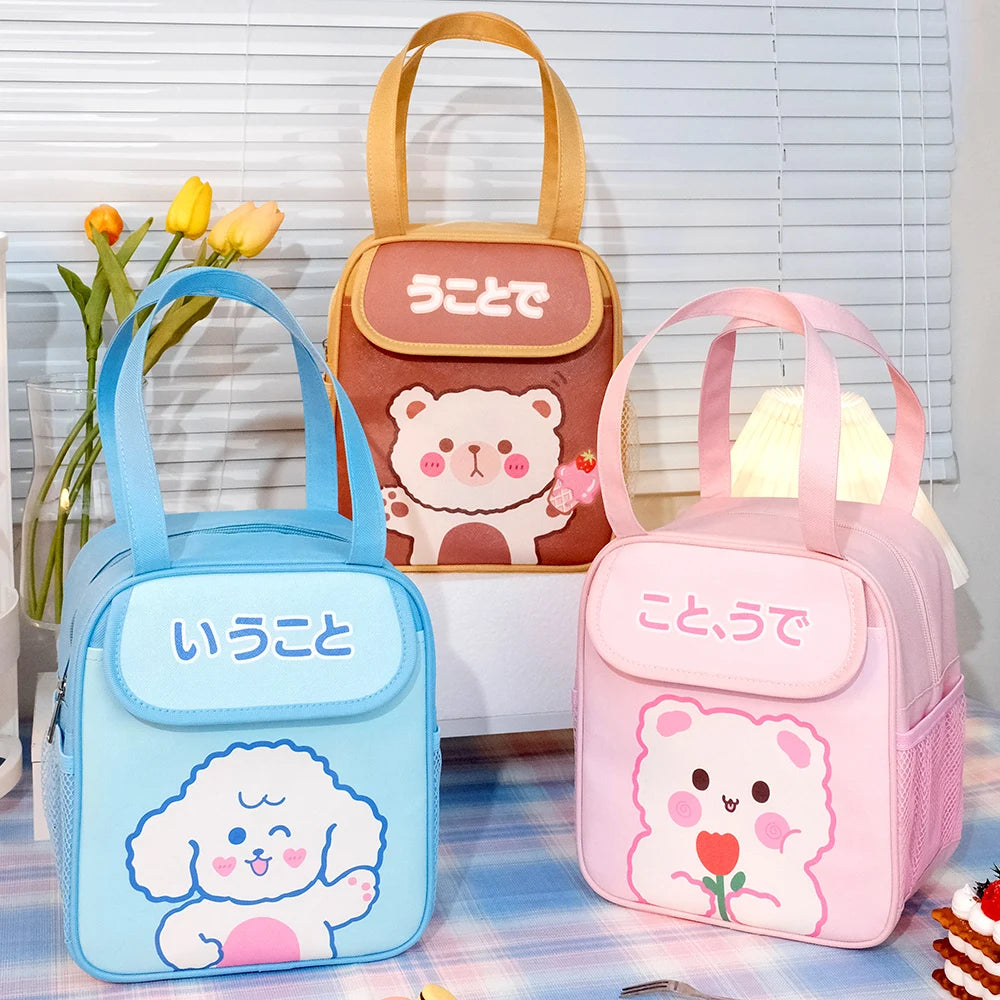 Three cute kawaii lunch bags with cartoon designs on a table.