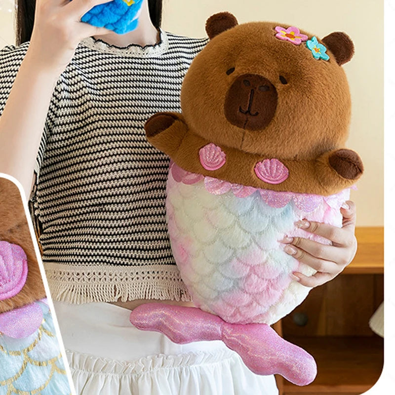 Capybara plush toy with mermaid tail held by a person