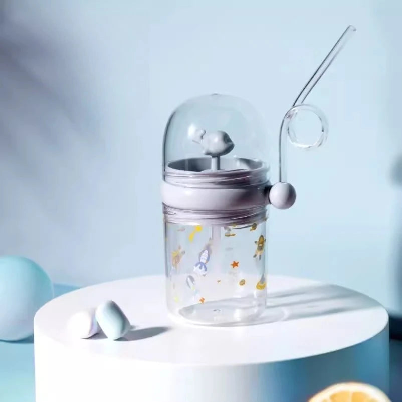Clear kawaii bottle with purple lid and straw on a white surface with a light blue background