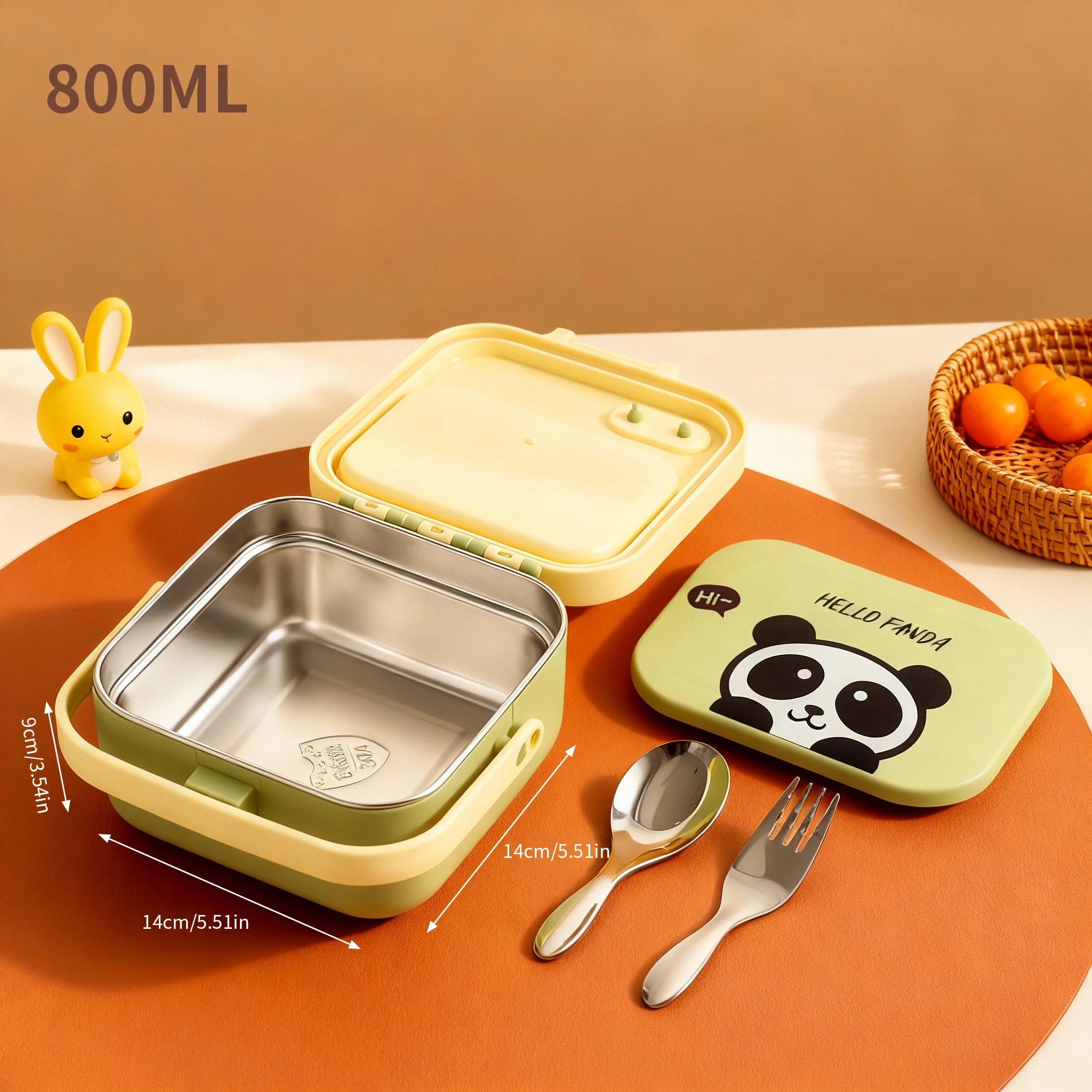 Children's stainless steel kawaii lunch box with panda design, spoon, and fork on an orange surface.