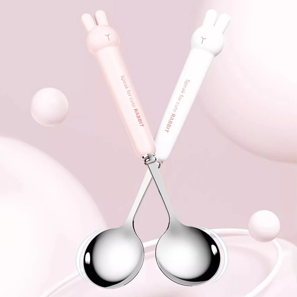Two silver kawaii utensils with white handles on a pink background