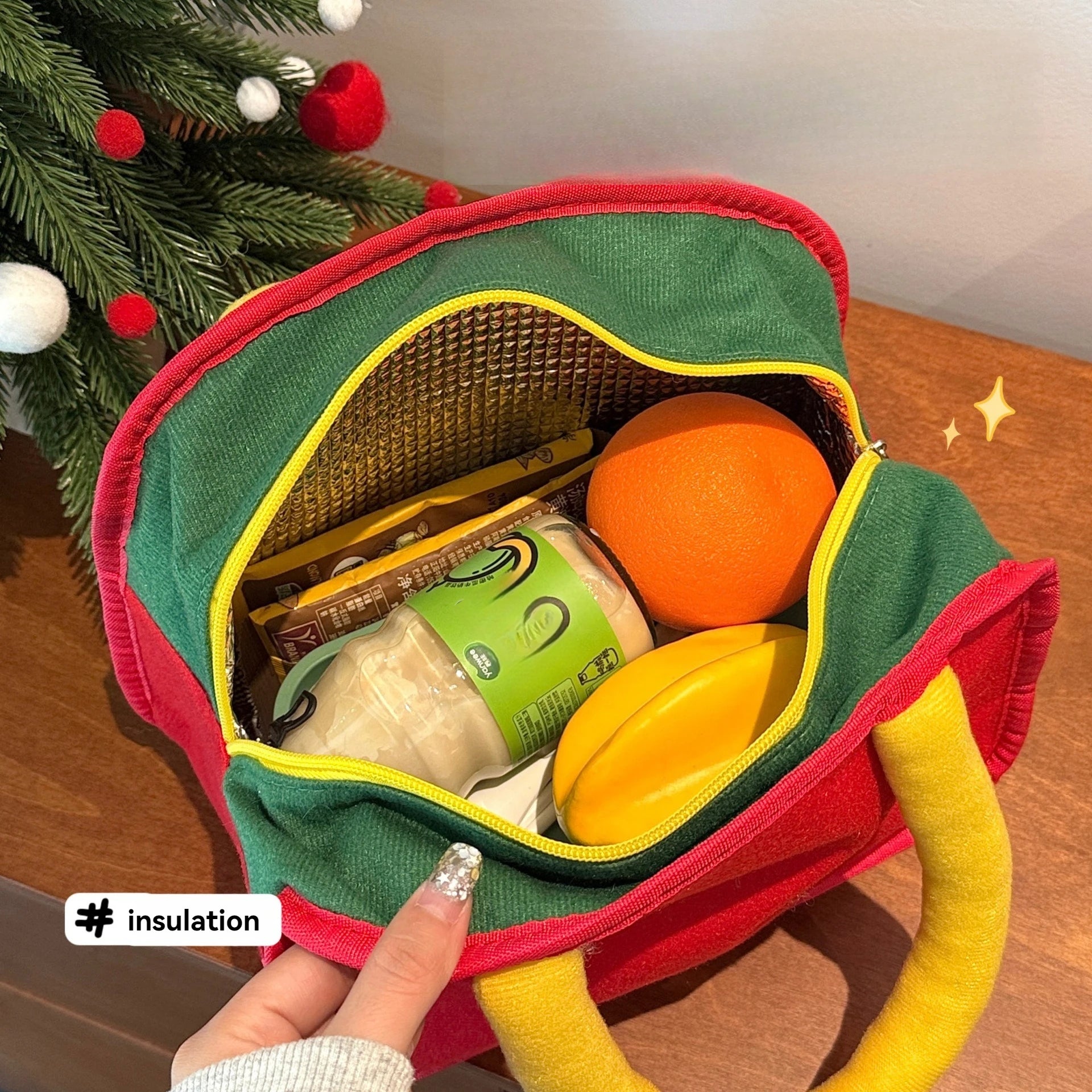 Green kawaii lunch bag with food items in front of a Christmas tree