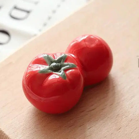 Red kawaii tomato-shaped object on a wooden surface with a blurred background