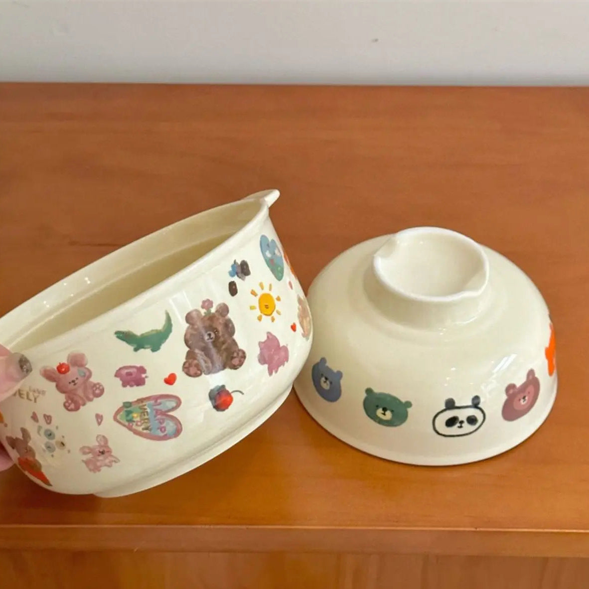 Ceramic kawaii bowls with cartoon designs on a wooden surface