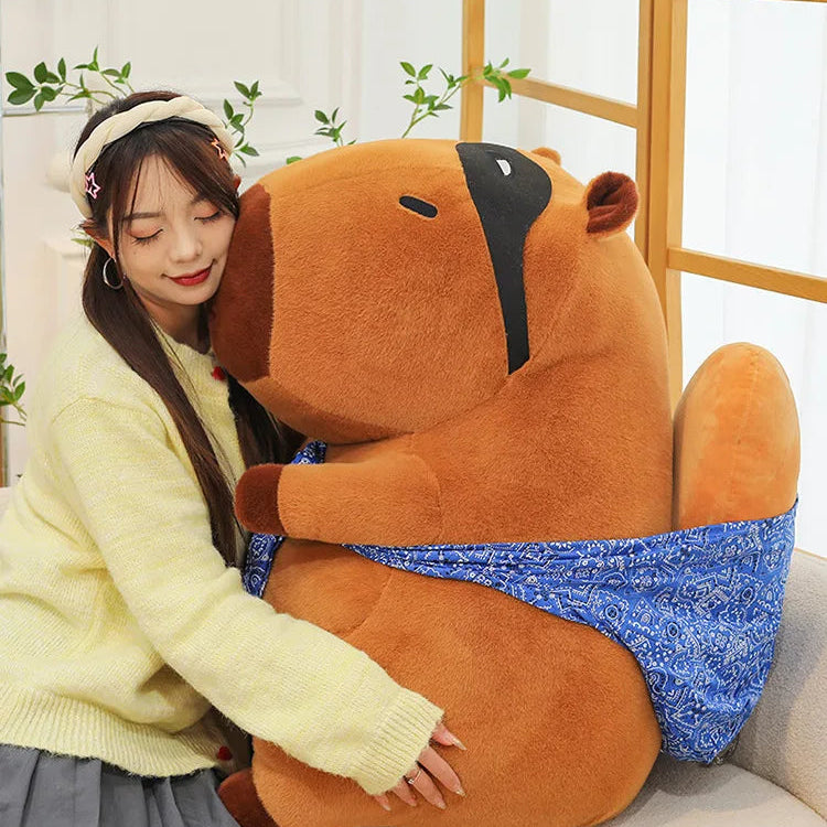 Person sitting on a couch with a large brown kawaii plush toy resembling a bear.