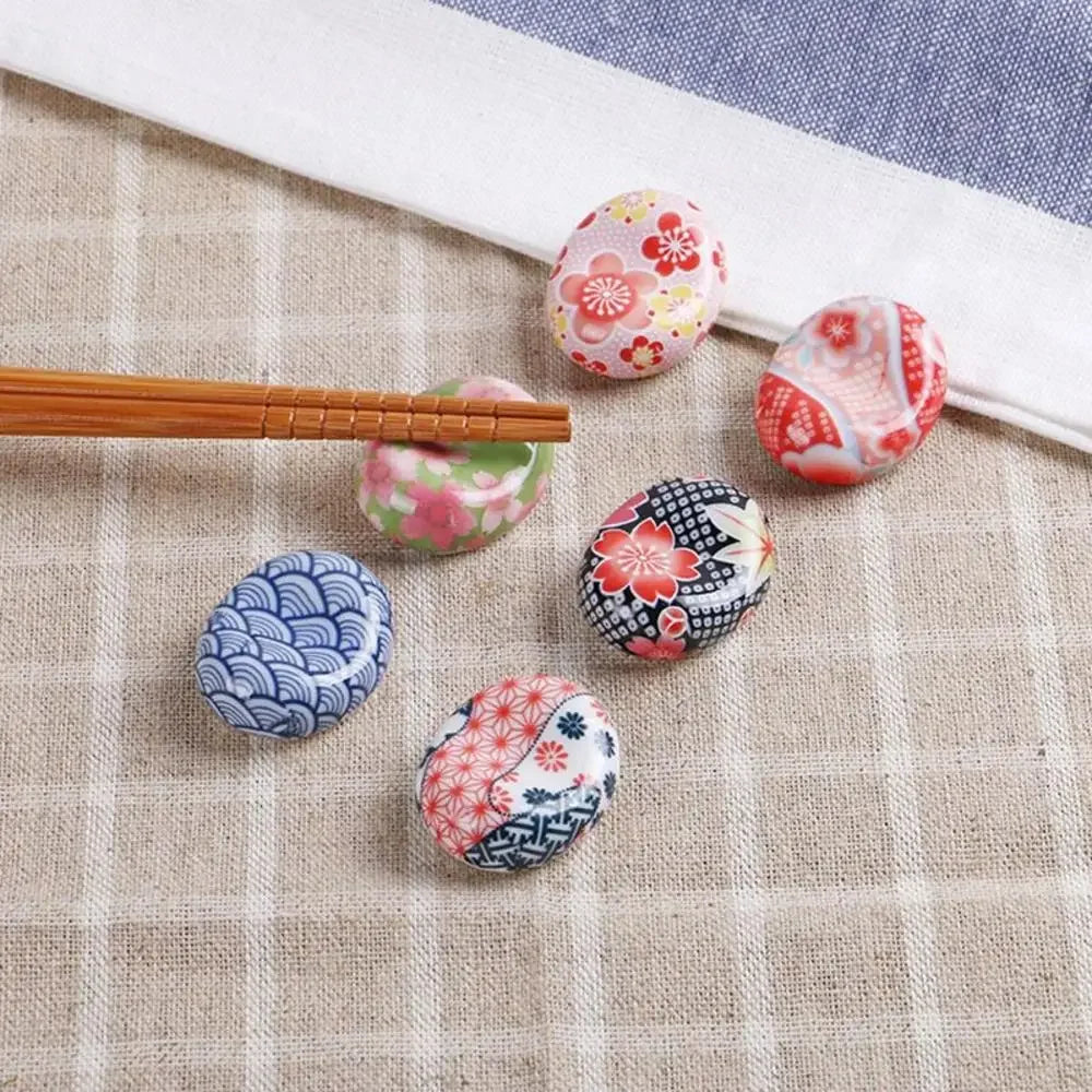 Decorative kawaii chopstick rests with floral patterns on a checkered tablecloth