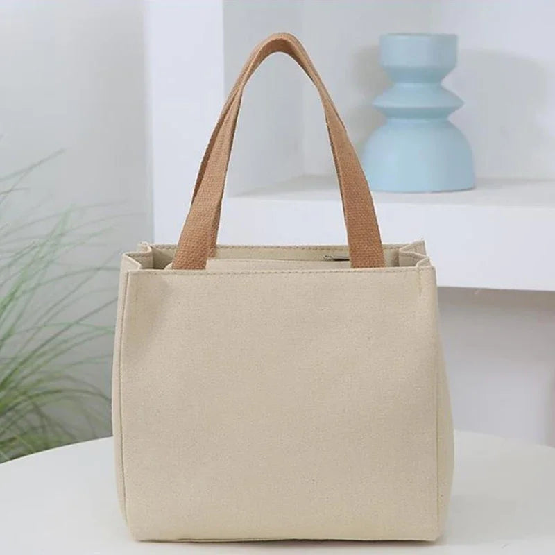 Beige kawaii tote bag with brown handles on a white surface with a light blue candle in the background.