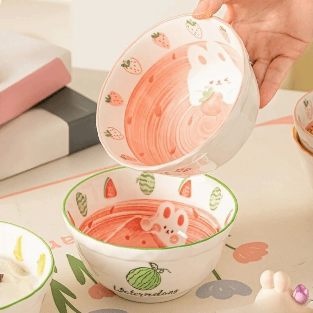 Person holding a kawaii ramen bowl with cartoon designs.