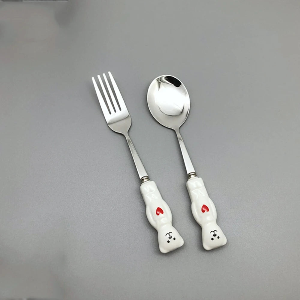 White, bear shaped kawaii utensils on a gray background