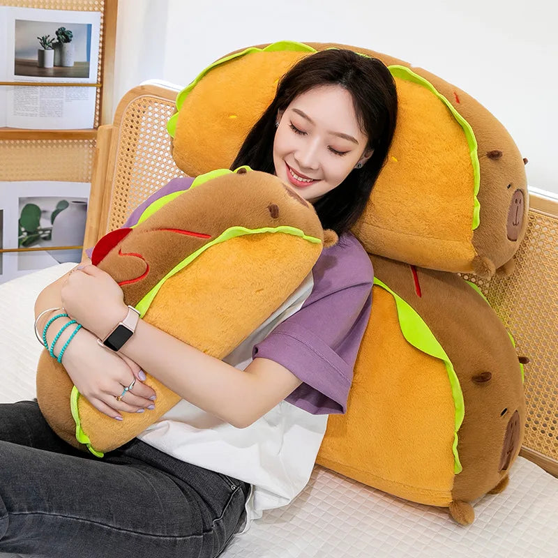 Person hugging a large, kawaii plush taco-shaped pillow in a cozy room.