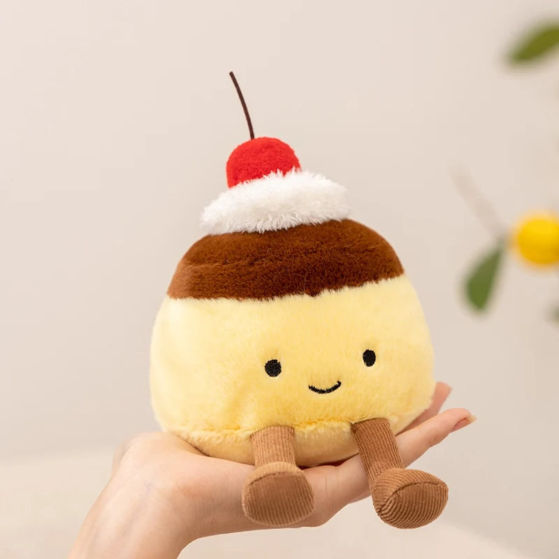 Kawaii plush toy resembling a ice cream sundae with a cherry on top held in a hand against a neutral background.