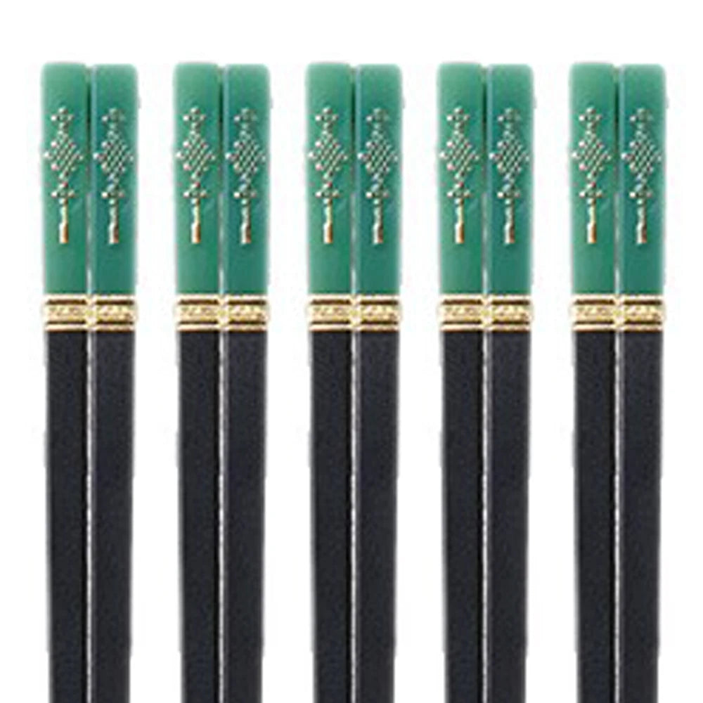 Set of six black kawaii chopsticks with green handles featuring gold patterns on a white background