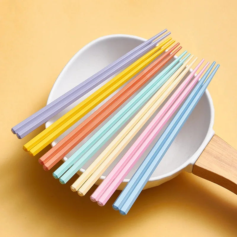Set of colorful kawaii chopsticks on a white plate with a yellow background