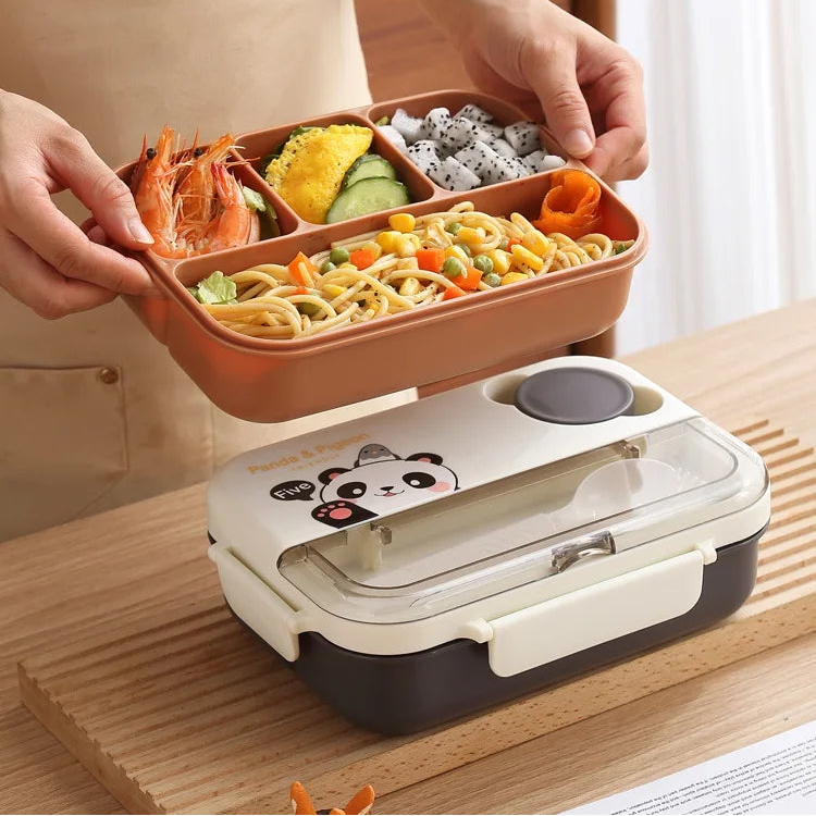 Person holding a kawaii bento box with food on a wooden table, next to a white lunch box with a cartoon design.