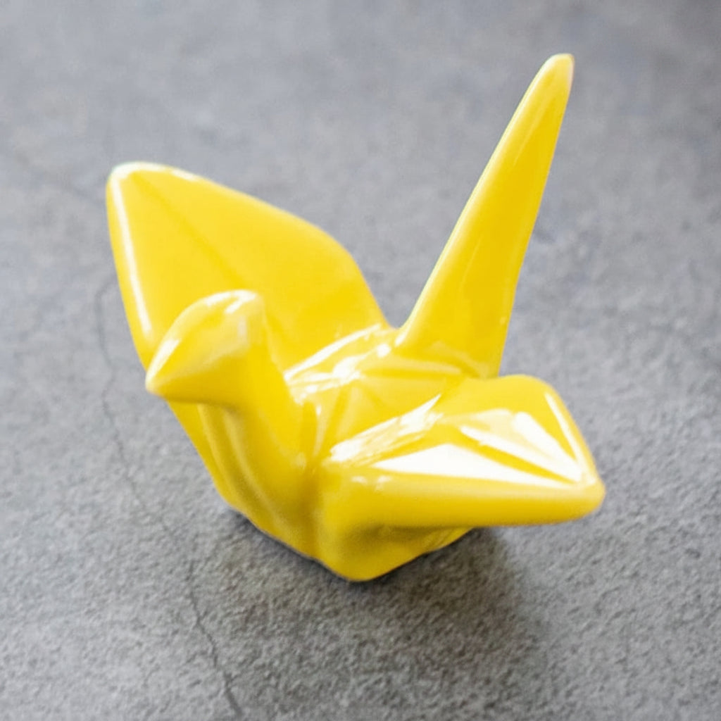 Yellow ceramic bird kawaii chopstick holders on a gray surface