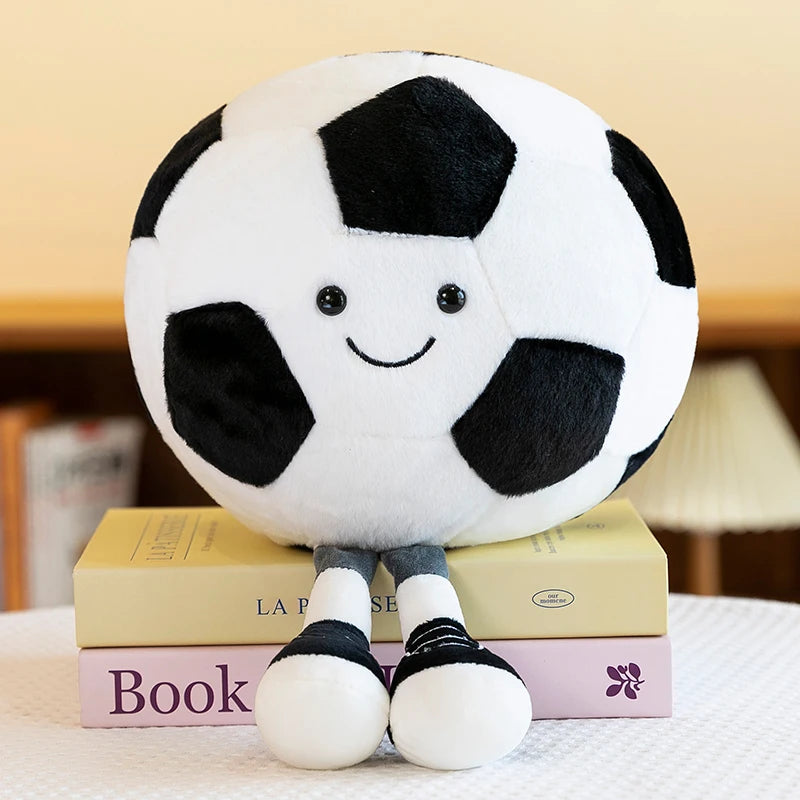 Kawaii plush toy soccer ball with a smiley face on top of books