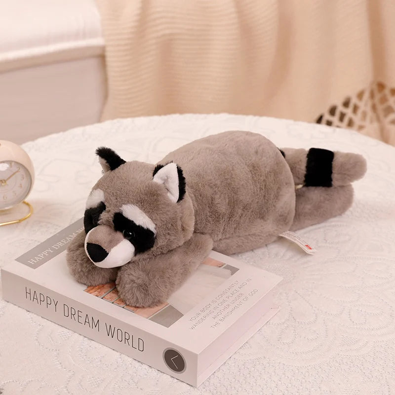 Kawaii plush raccoon toy on a book with a soft background