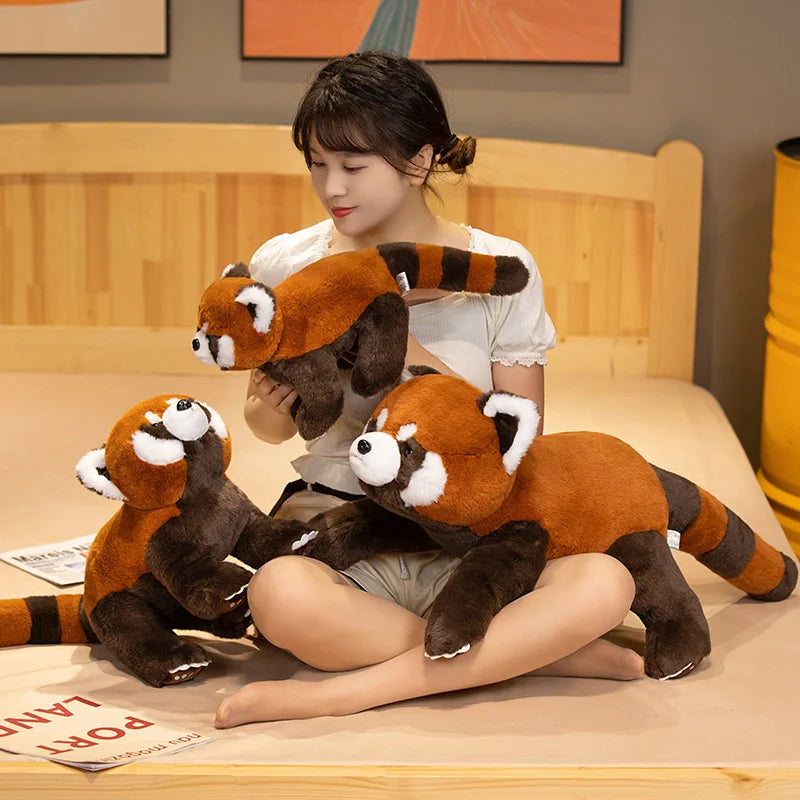 Woman holding and sitting with kawaii plush red pandas on a bed