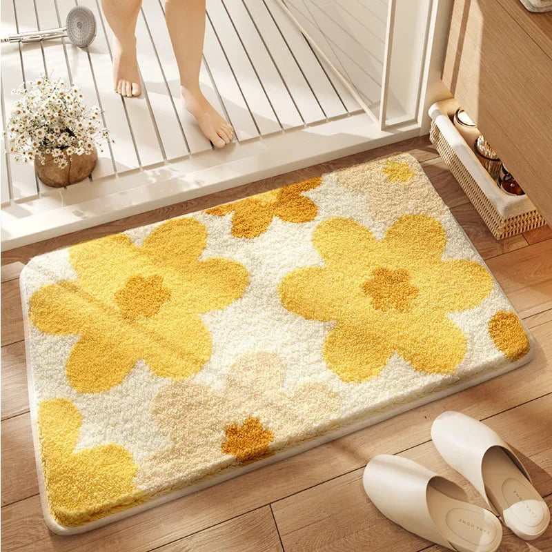 Yellow flower-patterned kawaii bath mat on a wooden floor with a person stepping onto it.