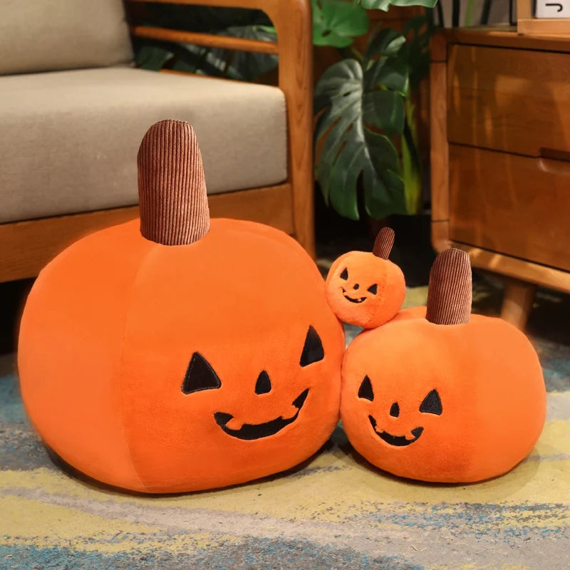 Three orange pumpkin-shaped kawaii cushions with smiling faces on a patterned rug.