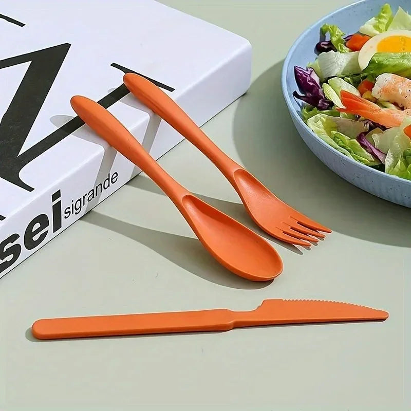 A set of orange kawaii utensils on a table