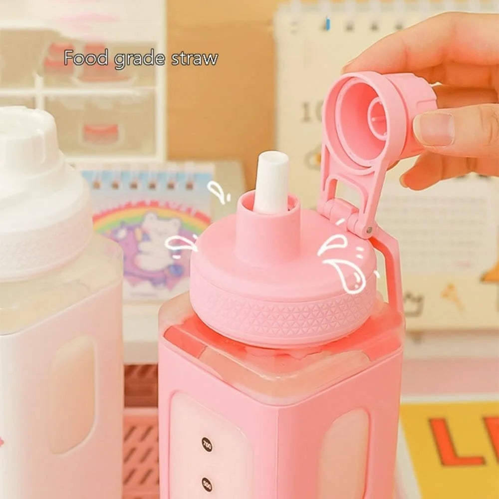 Pink kawaii water bottle with a straw cap being held by a hand, with a colorful background.