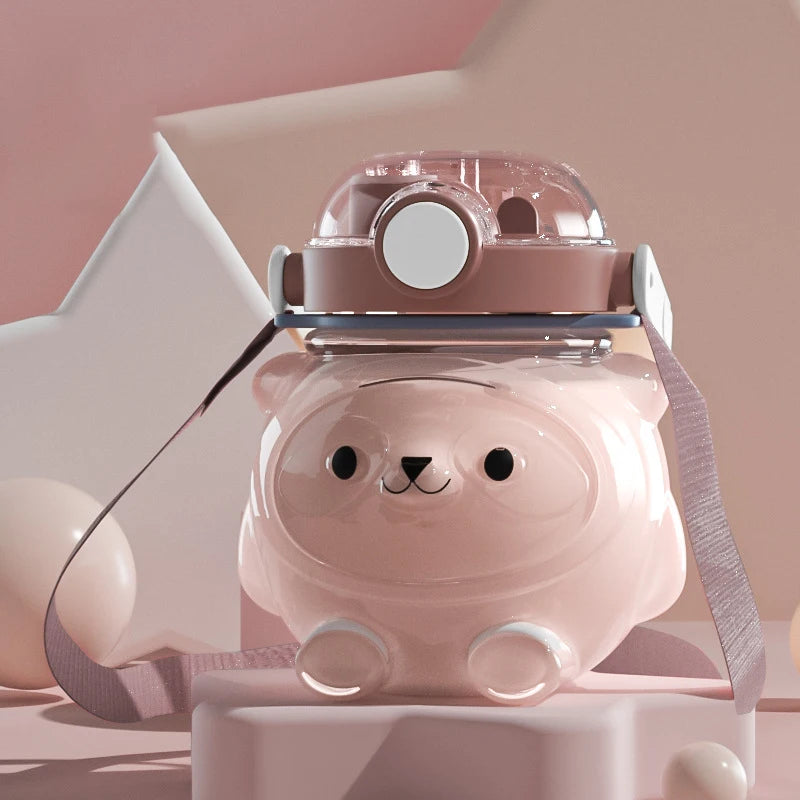 Pink bear-shaped kawaii water bottle with a strap on a pink background