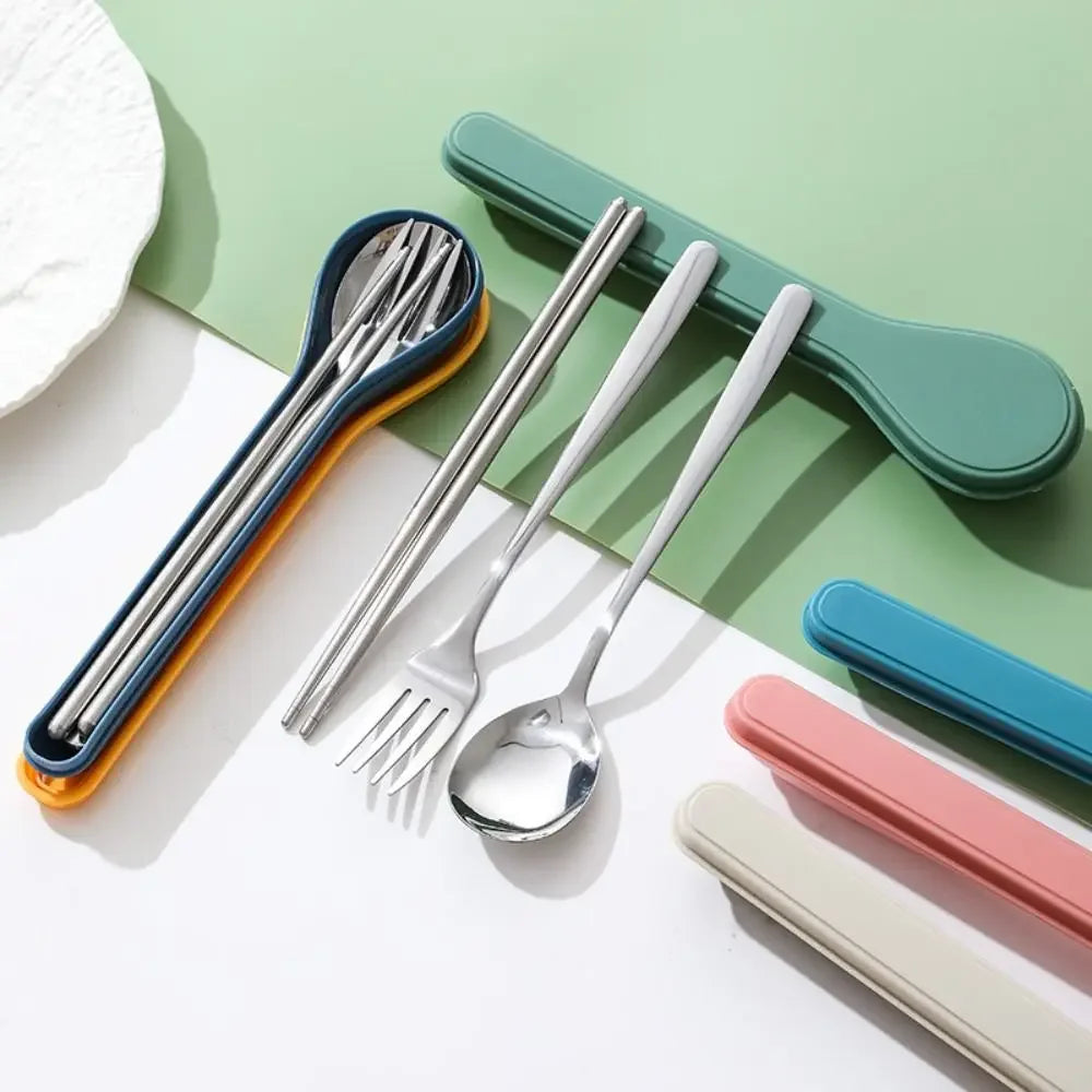 Set of stainless steel kawaii utensils with colorful handles on a green and white background