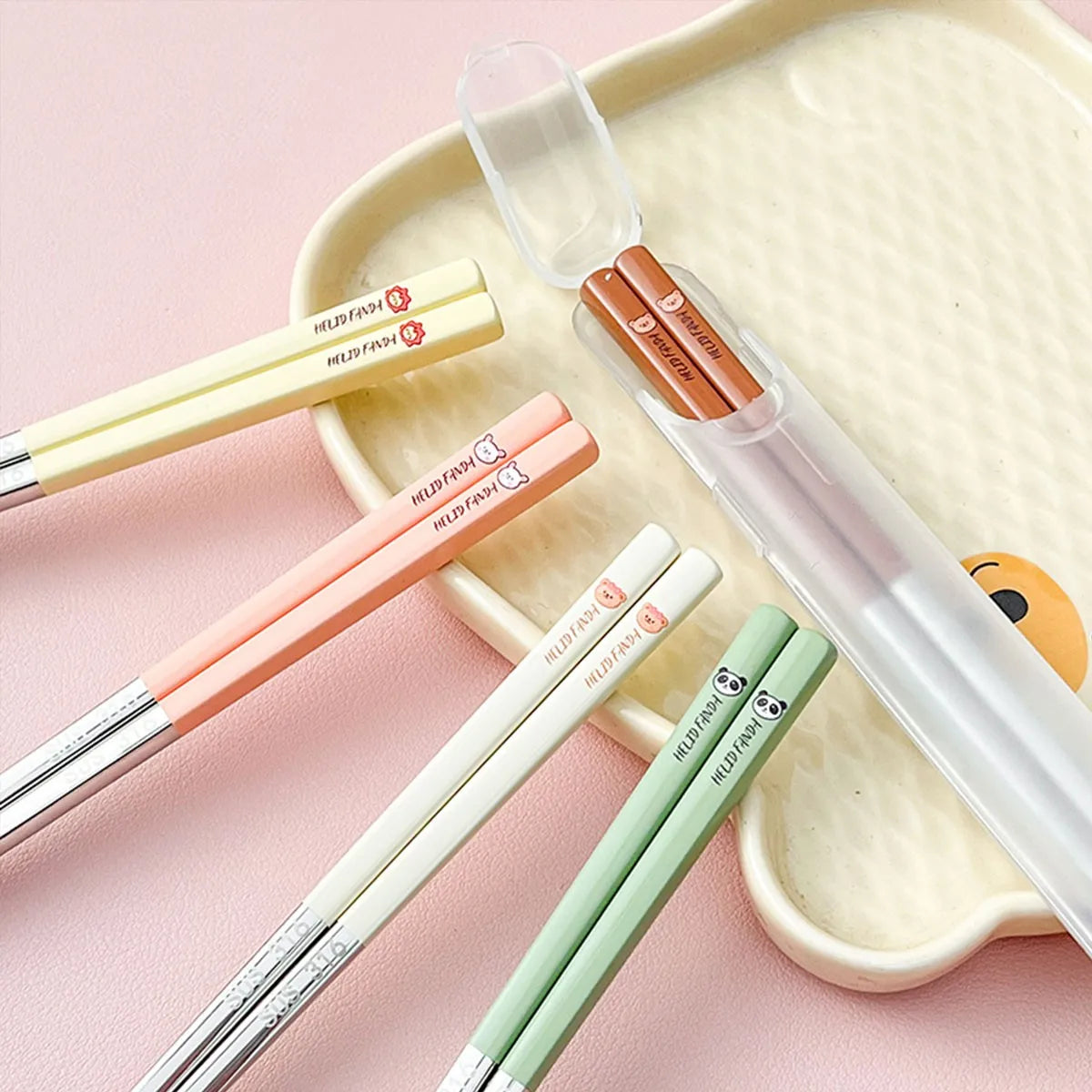 Set of colorful kawaii chopsticks with transparent cases on a pink background