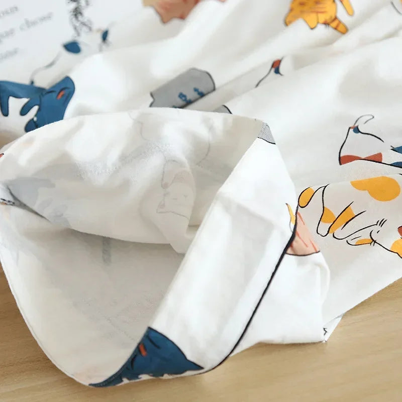 Close-up of a white pillow with kawaii cartoon animal designs on a wooden surface