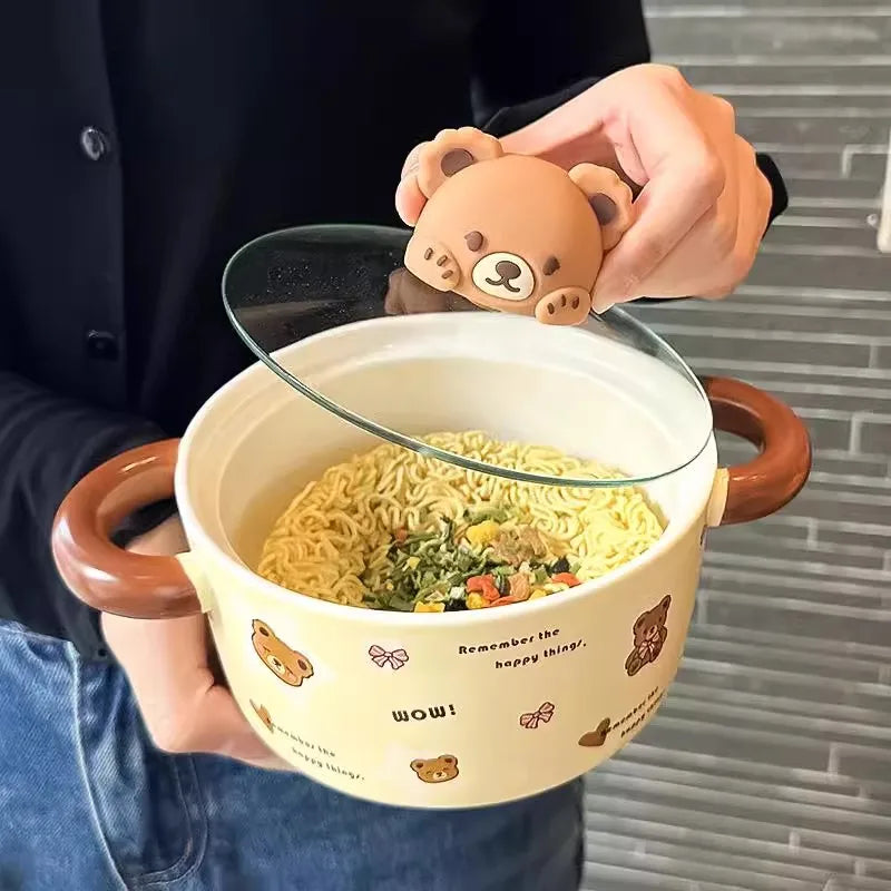A hand opening the lid of a bear themed kawaii ramen bowl
