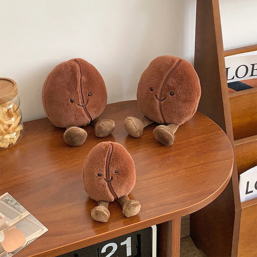 Three kawaii plush acorn toys on a wooden surface with a blurred background