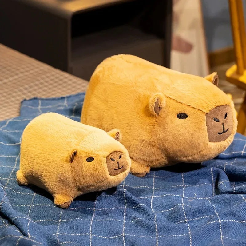 Two yellow kawaii plush toys resembling animals on a blue checkered blanket.