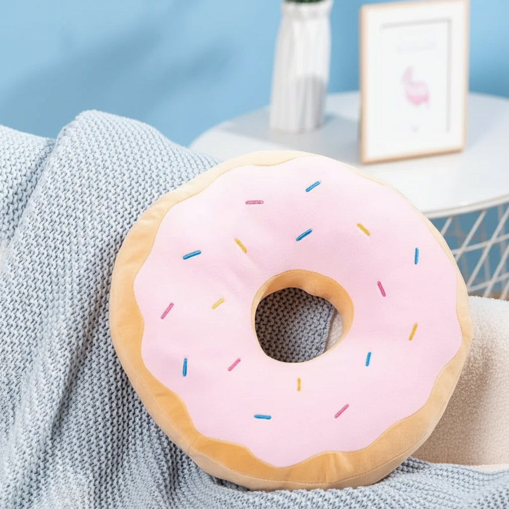 Donut-shaped kawaii cushion with pink icing and sprinkles on a textured surface